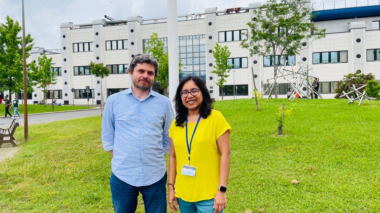 A person and person standing in front of a buildingDescription automatically generated